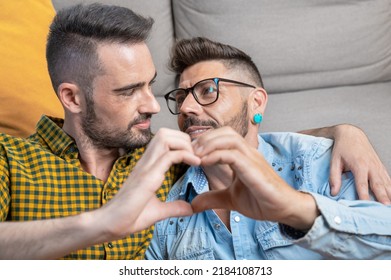 Young Gay Couple Smiling Confident Doing Heart Symbol With Hands At Home. High Quality Photography.