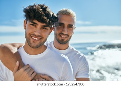 Young Gay Couple Smiling Happy Hugging At The Beach.