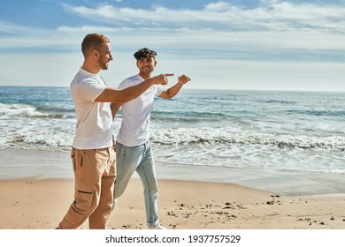 Young Gay Couple Smiling Happy Walking At The Beach.