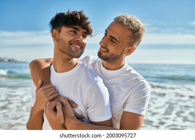 Young Gay Couple Smiling Happy Hugging At The Beach.