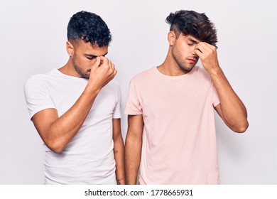 Young Gay Couple Wearing Casual Clothes Tired Rubbing Nose And Eyes Feeling Fatigue And Headache. Stress And Frustration Concept. 