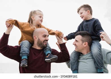 Young Gay Family Having Fun Together On The Beach In Summer Vacation - LGBT Dads And Sons Lifestyle Concept - Main Focus On Right Man Face