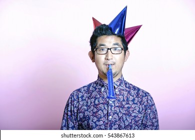 Young Geeky Asian Man wearing many party hats 