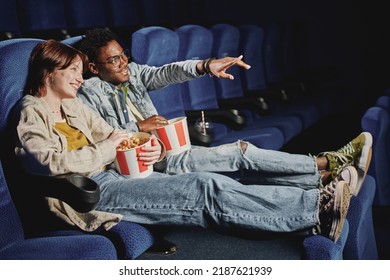 Young Gen Z African American Man And Caucasian Woman In Love Wearing Casual Clothes Enjoying Watching Action Movie At Cinema