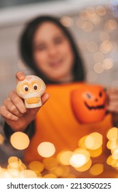 Young Generations Z Teen Boy In Orange Clothes While All Hallows Eve Photo Session At Home. Stylish Teenager With Cup Of Head Jack And Sweets Celebrates Halloween Holiday Enjoy Chocolate Candy