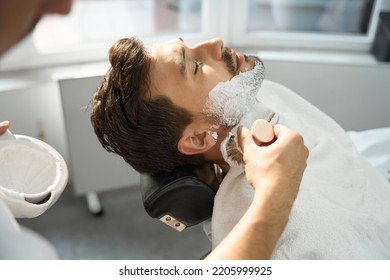 Young Gentleman Covered In Shaving Foam Resting In Barber Armchair