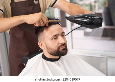 Young Gentleman Enjoying Himself During Hair Salon Procedures