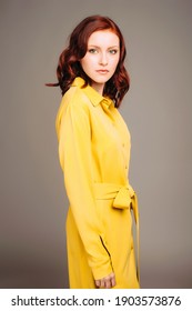Young ginger woman in yellow shirt dress. Female bright look, lemon casual style. Fashion portrait on neutral studio background.