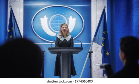 Young Girl Activist Delivering An Emotional And Powerful Speech At Press Conference In Government Building. Child Speaking To Congress At Summit Meeting. Backdrop With European Union Flags.