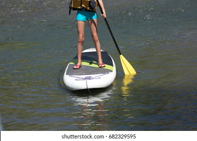 Young Girl Activity  On Stand Up Paddle Board, In The River Waters. Fun Family Activity  And Healthy Lifestyle.