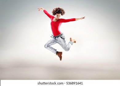 Young girl with afro jumping, flying, dancing in studio.