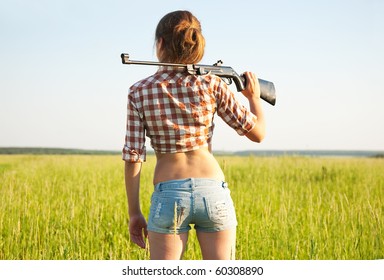 young girl with air rifle against field