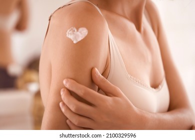 A Young Girl Applies A Moisturizer To Her Skin, A Woman Gently Cares For Her Body, Depicts A Heart With A Cream, Taking Care Of Herself, Beauty And Health.