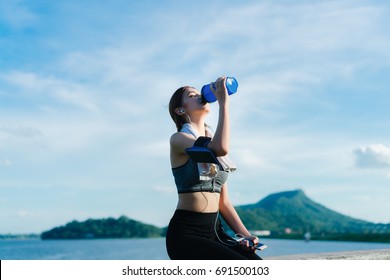 Young Girl Asian Drinking Protein Shake Nutrition And Listen Music After Exercise Running Workout Outdoor At Beach Seaside In Summer For Muscle Building And Slim Fit Body Nice Strong Perfect.