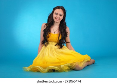 Young Girl In Ballroom Dress On Blue Studio Background.