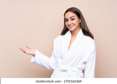 Young girl in a bathrobe over isolated background holding copyspace imaginary on the palm - Powered by Shutterstock