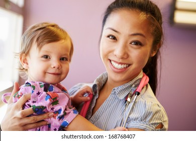 Young Girl Being Held By Female Pediatric Doctor