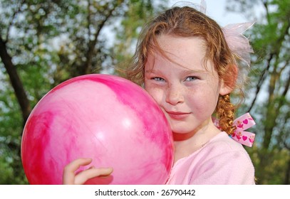 Young Girl With Big Bouncy Ball Outdoors