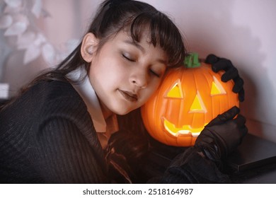 Young girl in black dress fall asleep at pumpkin or jack-o'-lantern, Halloween concept - Powered by Shutterstock