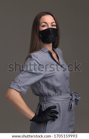 
Young girl in black rubber gloves and a mask.