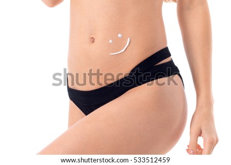 young girl in black swimsuit and skin protector cream on her belly isolated on white background