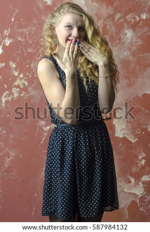 Young girl with blonde curly hair in a long dress with polka dots