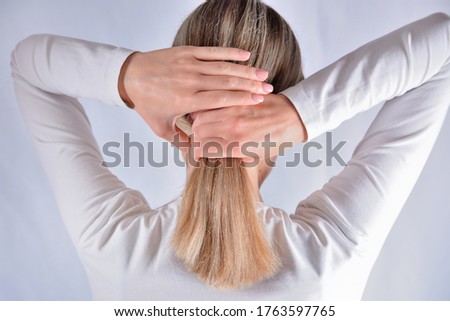 Young girl with blonde shaggy hair change hairstyles with hands. Attractive skinny girl isolated on studio white. Cares about healthy and clean hair. Close up, selective focus