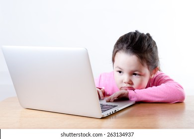 A Young Girl Is Bored While Using A Computer.