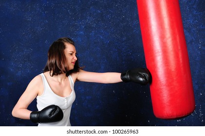 Young girl boxing a punchbag with all her efforts - Powered by Shutterstock