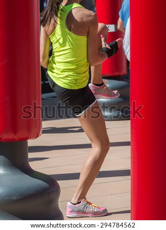 Young Girl Boxing and Punching Bag in background, Female Kickboxing Exercise