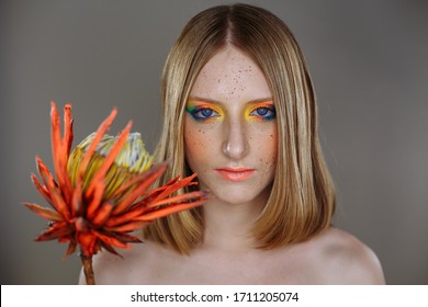 Young girl with bright makeup and a bright flower