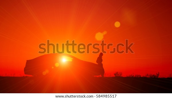 Young girl with and broken\
car. Silhouette of sedan car with girl on the background of\
beautiful sunset