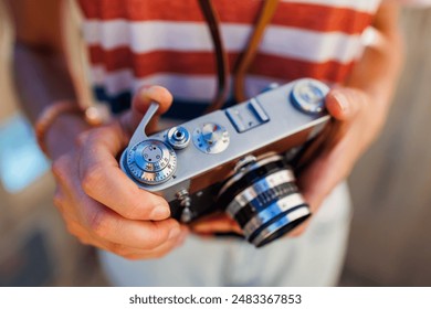 young girl with a camera.  the photographer adjusts the camera. Stylish girl with a film camera. film camera close up. adventures and travel. - Powered by Shutterstock