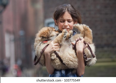 young girl carries a cute Elo puppy that is injured