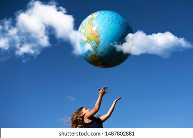 Young girl catches planet Earth. Happy child with globe in raised hands on blue sky background. Environment and ecology protection concept. World Earth Day greeting card, postcard idea - Shutterstock ID 1487802881
