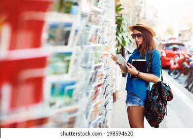 young girl chooses a postcard
