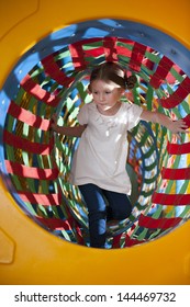 Young Girl Climbs Through Netted Tunnel In Soft Play Center