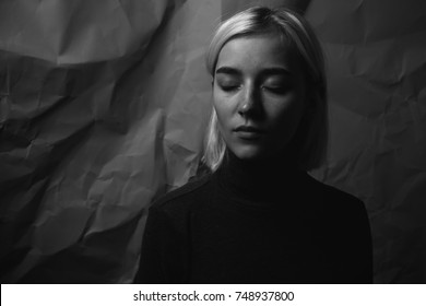 Young Girl With Closed Eyes Near Crumpled Background. Black And White