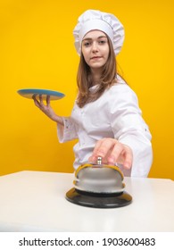 Young Girl Cook. Woman Chef On A Yellow Background. Wipe The Restaurant Chef. She Pushes Bell. Girl Works As A Cook In A Restaurant. Chef Career. Girl Cook In Uniform Restaurant Worker.