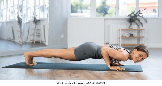 Young girl couch train during hatha yoga class, perform exercises and stretches to improve physical health. Teacher working out practice Chaturanga dandasana - Powered by Shutterstock