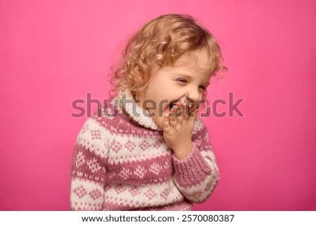 Similar – Image, Stock Photo Child laughing joyfully while making a snow angel, dressed in a vibrant winter coat and hat