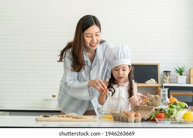 Young Girl And Daughter Learned To Cook Breakfast With Mom. A Beautiful Asian Woman Was Happy In The Kitchen At Home. 