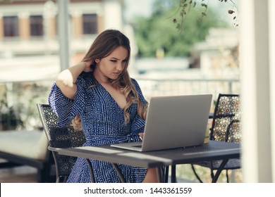 Young girl digital nomad freelancer entrepreneur working uncomfortable outdoor at a laptop suffering from a nech pain neckache inflammation . traveler lifestyle remote working illness