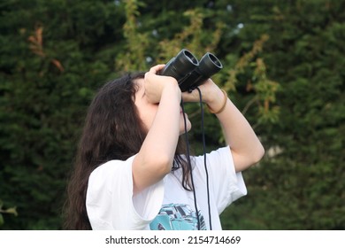 Young girl is discovering the surrouding she is looking through a binocular.