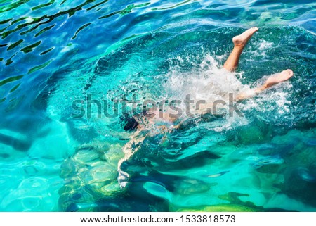 Young girl with diving mask and snorkel dives in clear blue sea water, adult woman in white bikini swims in turquoise clean transparent ocean water, tropical coral reef snorkeling on summer holidays