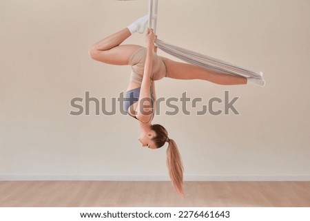 Young girl do fly yoga and stretches,yoga training, fly yoga, aerostretching, aerial yoga hammock,pilates therapy concept. Copy space.
