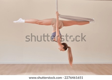 Young girl do fly yoga and stretches,yoga training, fly yoga, aerostretching, aerial yoga hammock,pilates therapy concept. Copy space.