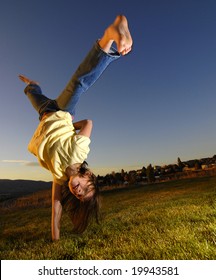 Young girl doing cartwheel across green grass