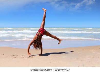 Young girl doing a cartwheel on the beach 