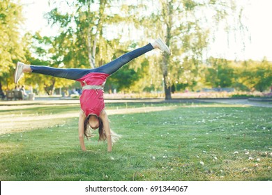 Young girl doing a cartwheel outdoors at park